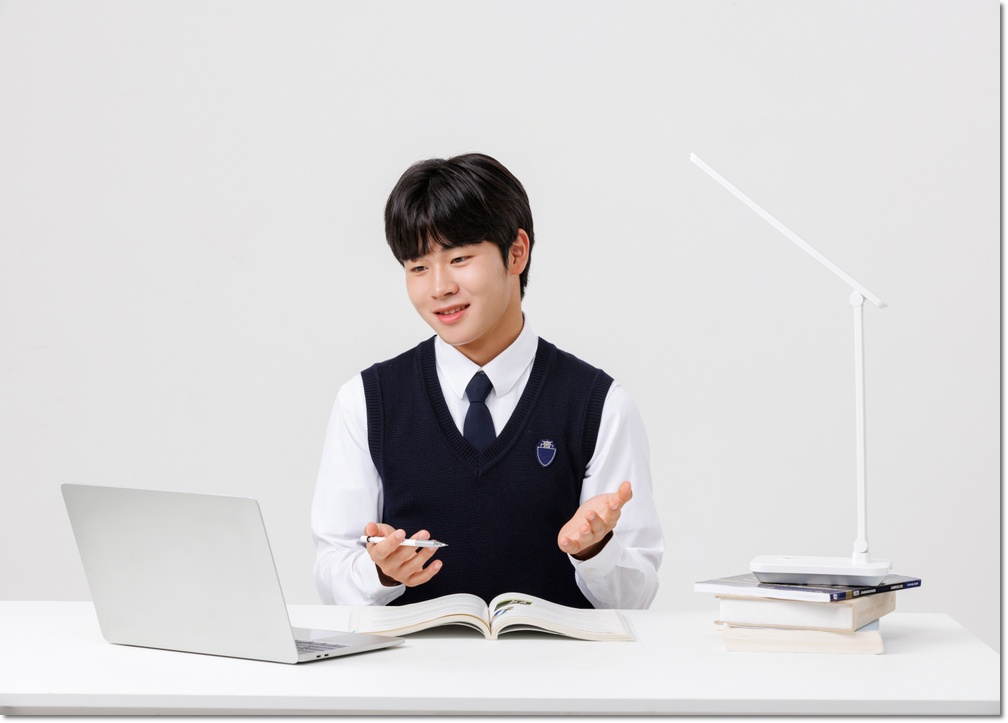 노트북 앞에 앉아 공부하는 학생